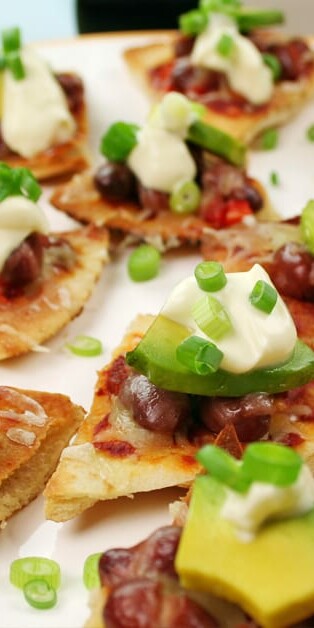 tex mex pita nachos on plate with avocados and sour cream